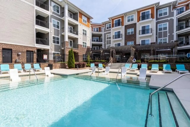 Blue lounge chairs next to pool exterior at The Eastern On 10th in Greenville Student Accommodation