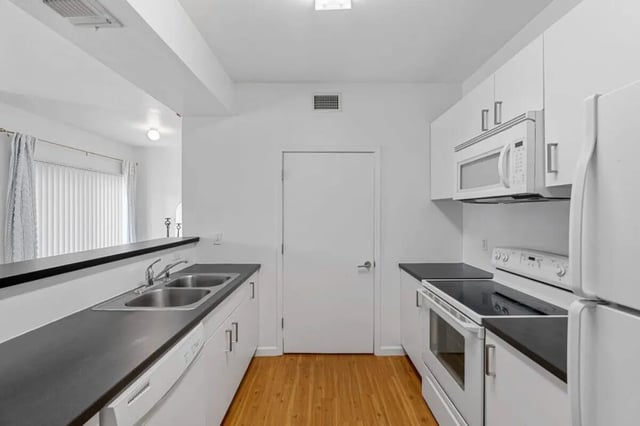 White cabinets stove microwave sink kitchen at Green Spring in San Marcos Student Accommodation