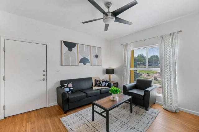 Black sofa armchair coffee table abstract art living room at Green Spring in San Marcos Student Accommodation