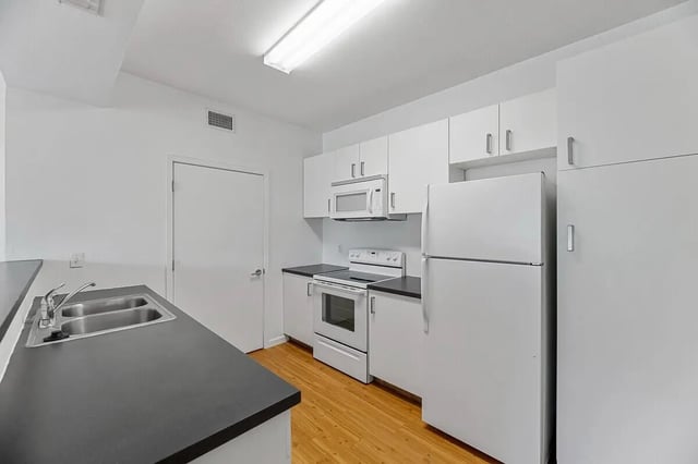 White kitchen cabinets stove refrigerator sink kitchen at Green Spring in San Marcos Student Accommodation