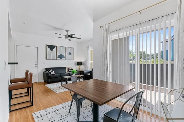 Modern living room with black sofa dining table living room at Green Spring in San Marcos Student Accommodation