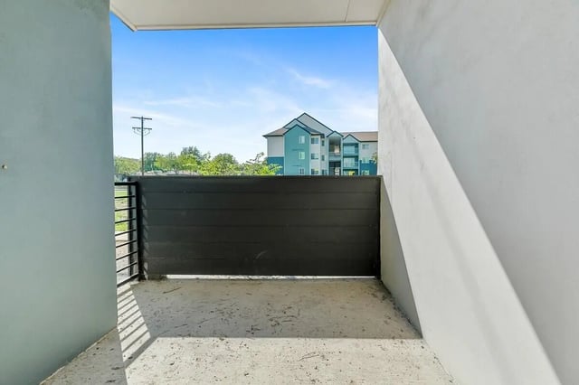 Concrete patio black gate apartment building exterior at Green Spring in San Marcos Student Accommodation