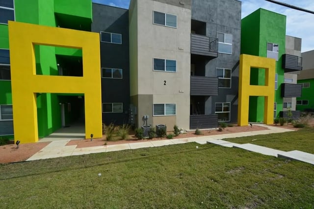 Colorful apartment building with yellow entryway exterior at Green Spring in San Marcos Student Accommodation