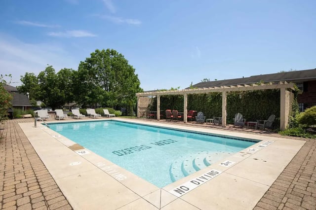 Swimming pool with lounge chairs and seating area Outdoor Pool at Oxford West Apartments in Oxford Student Accommodation