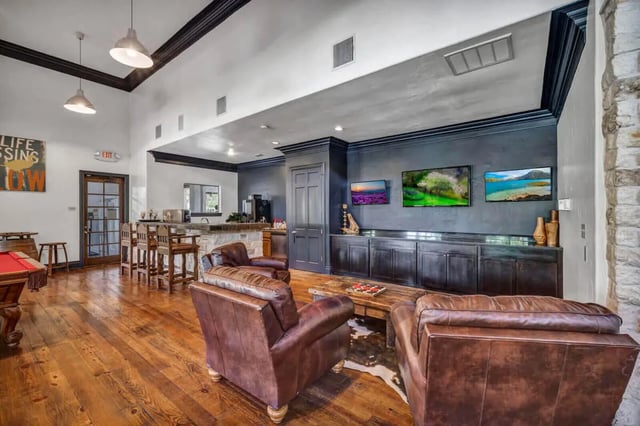 Pool table leather chairs TVs and bar living room at The Ranch Student Apartments in San Marcos Student Accommodation