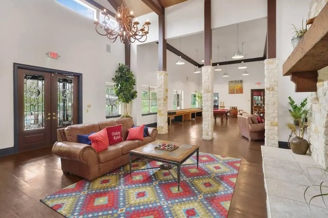 Leather sofa with pillows colorful rug living room at The Ranch Student Apartments in San Marcos Student Accommodation