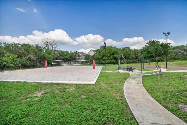 Sand volleyball court with picnic tables outdoor playing area at The Ranch Student Apartments in San Marcos Student Accommodation