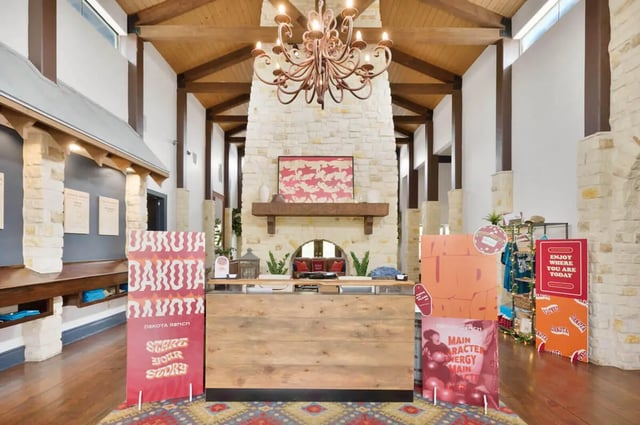 Reception desk with fireplace and signage lobby at The Ranch Student Apartments in San Marcos Student Accommodation