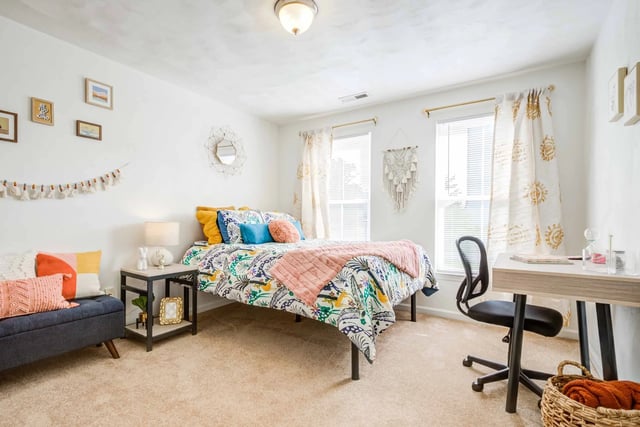 Bed with colorful bedding desk chair basket bedroom at Maple Ridge Townhomes in Blacksburg Student Accommodation