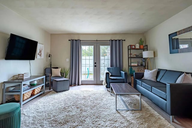 Sofa armchairs coffee table rug living room at Maple Ridge Townhomes in Blacksburg Student Accommodation