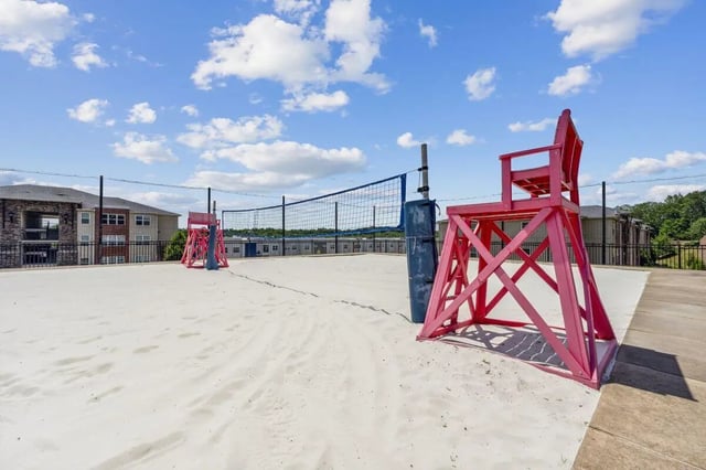 Sand volleyball court with red chairs playing area at The View Apartments in State College Student Accommodation