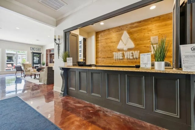 Reception desk with logo and seating area. at The View Apartments in State College Student Accommodation