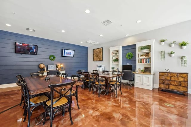 Two TVs tables chairs and bookshelves communal area at The View Apartments in State College Student Accommodation