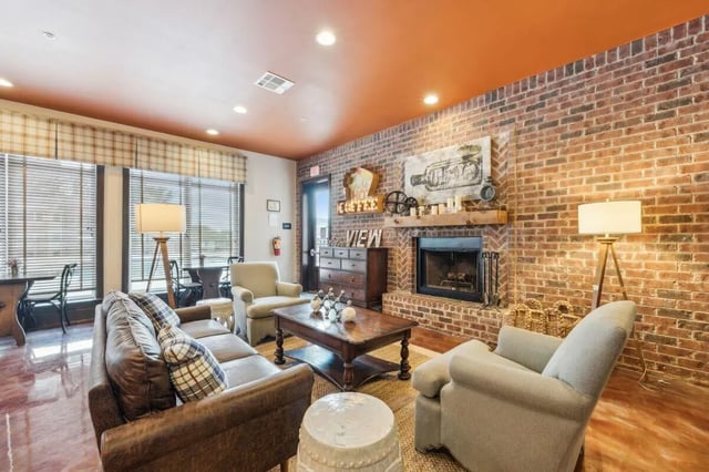 Leather sofas fireplace coffee table living room at The View Apartments in State College Student Accommodation