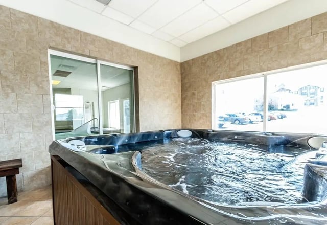 Jacuzzi and pool area with tiled walls and windows recreation area at Alpine Chalet in Rexburg Student Accommodation