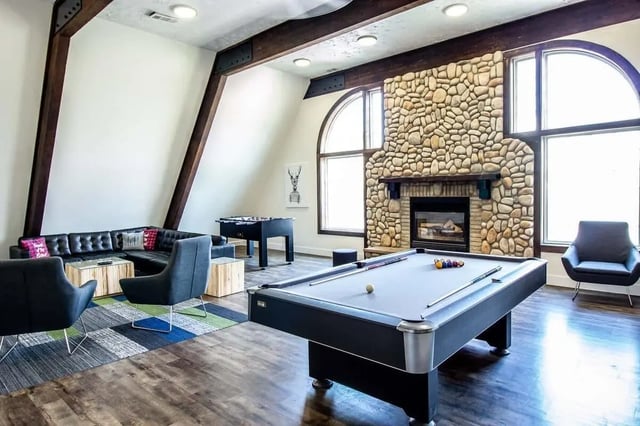 Pool table foosball fireplace sectional living room Image at Alpine Chalet in Rexburg Student Accommodation