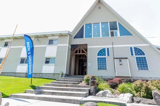 Apartment building with entrance and flags exterior at Alpine Chalet in Rexburg Student Accommodation