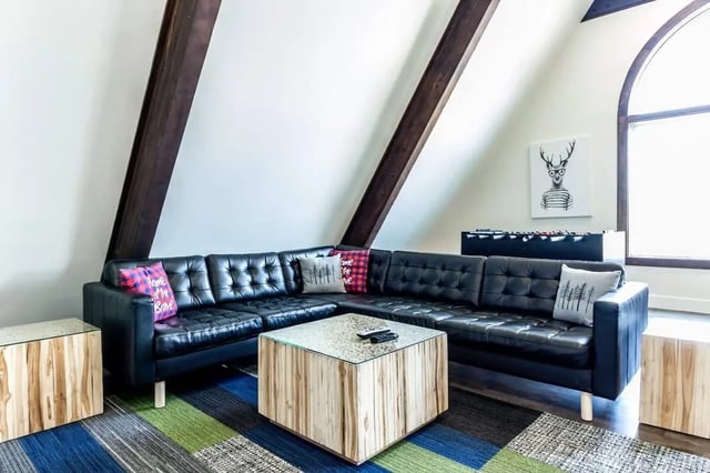 Black leather sectional couch wood tables living room at Alpine Chalet in Rexburg Student Accommodation
