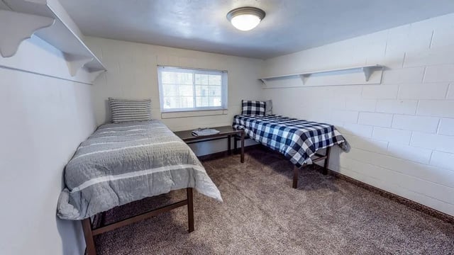 Two beds table window shelves bedroom at Alpine Chalet in Rexburg Student Accommodation
