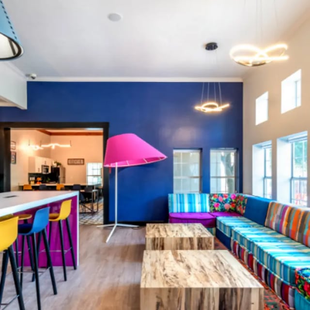 Colorful sectional couch bar stools large pink lamp living room at The Cottages at Hillside Ranch in San Marcos Student Accommodation