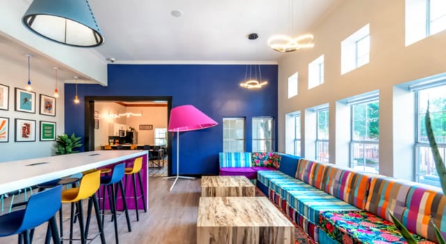 Colorful sectional sofa bar stools and art common area at The Cottages at Hillside Ranch in San Marcos Student Accommodation