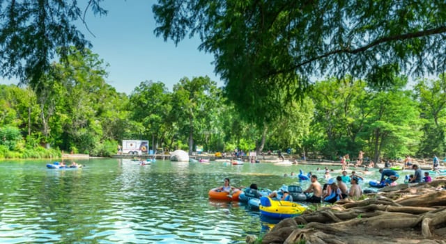 People tubing on river near trees playing area at The Cottages at Hillside Ranch in San Marcos Student Accommodation