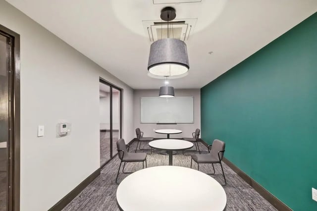 Tables chairs whiteboard study area at The Main on University in Fairfax Student Accommodation