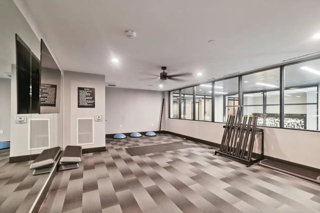 Exercise equipment mirrors and ceiling fan gym at The Main on University in Fairfax Student Accommodation