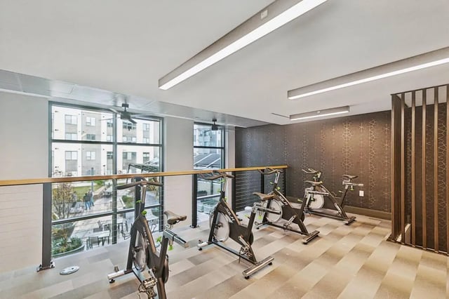 Several exercise bikes in a modern gym at The Main on University in Fairfax Student Accommodation