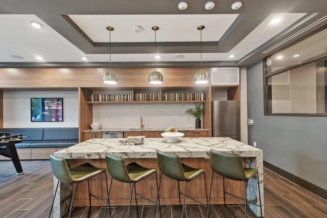 Kitchen island with bar stools and foosball table living area. at The Main on University in Fairfax Student Accommodation