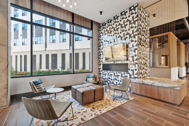 Modern lounge with patterned wall fireplace and seating living room at The Main on University in Fairfax Student Accommodation