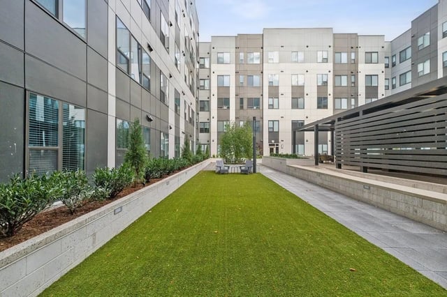 Artificial turf lawn with chairs and outdoor seating area exterior at The Main on University in Fairfax Student Accommodation