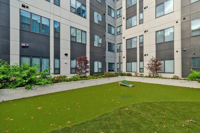 Cornhole set on grass courtyard exterior at The Main on University in Fairfax Student Accommodation