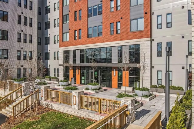 Modern building entrance with planters and railing exterior at The Main on University in Fairfax Student Accommodation