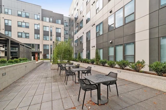 Outdoor seating area with tables and chairs exterior at The Main on University in Fairfax Student Accommodation