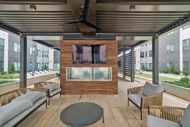 Sofas chairs fireplace TV on wooden wall patio at The Main on University in Fairfax Student Accommodation