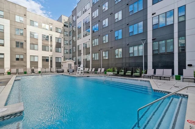 Swimming pool with lounge chairs and modern building exterior exterior at The Main on University in Fairfax Student Accommodation