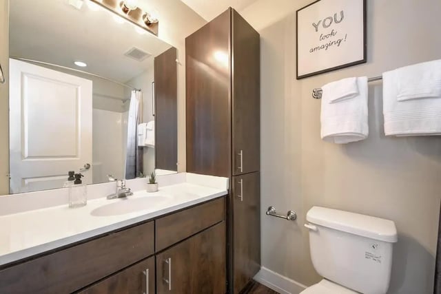 Sink vanity toilet towels tall cabinet bathroom at The Avenue at Orono in Orono Student Accommodation