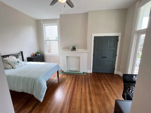 Bed dresser fireplace double doors bedroom at College Corners on High in Farmville Student Accommodation