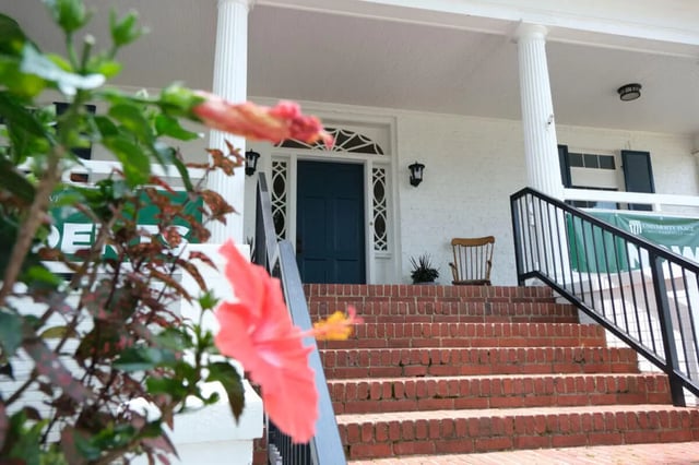 Steps up to blue door red hibiscus exterior at College Corners on High in Farmville Student Accommodation
