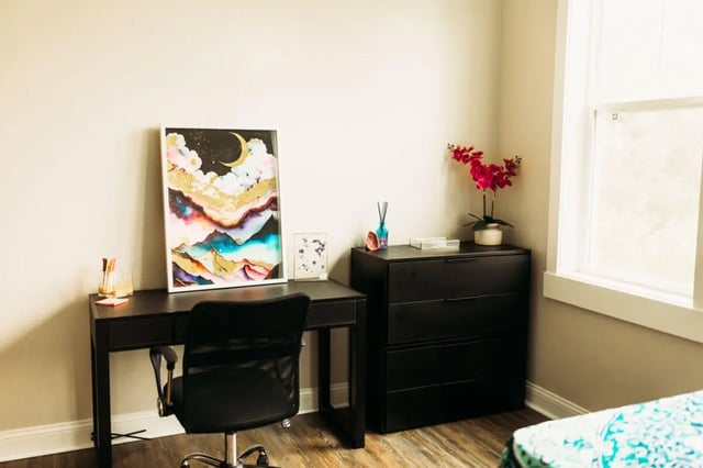 Desk chair dresser artwork flowers study area at College Corners on High in Farmville Student Accommodation