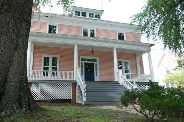 Pink house with white columns and steps exterior at College Corners on High in Farmville Student Accommodation