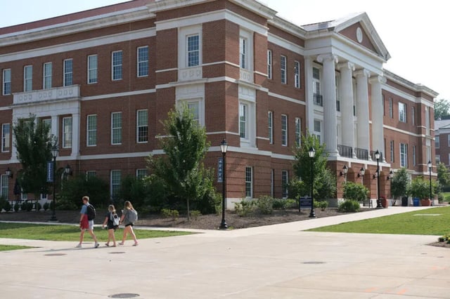 Brick building with students walking exterior at College Corners on High in Farmville Student Accommodation