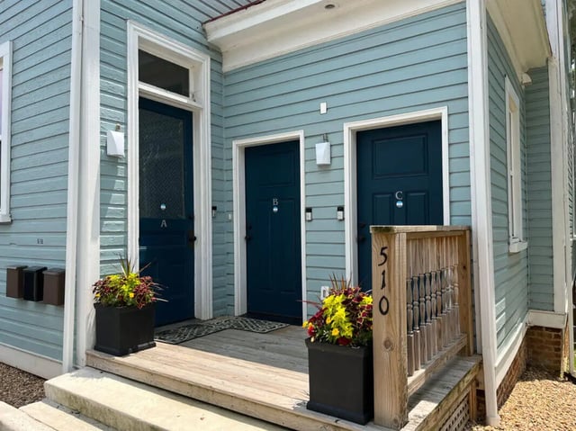 Three dark blue doors with potted plants exterior at College Corners on High in Farmville Student Accommodation