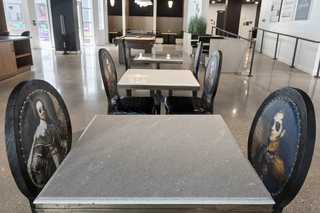 Marble tables with ornate portrait chairs common area at Atmosphere Lincoln in Lincoln Student Accommodation