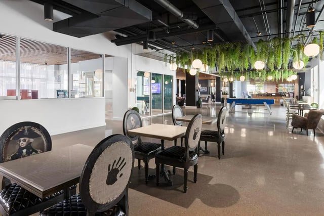Tables and chairs with art work in communal area at Atmosphere Lincoln in Lincoln Student Accommodation