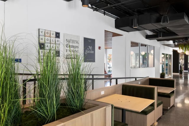 Seating booths with tables and plants lounge area at Atmosphere Lincoln in Lincoln Student Accommodation