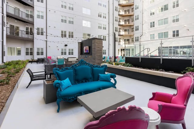 Ornate turquoise couch gray table pink chairs lounge area at Atmosphere Lincoln in Lincoln Student Accommodation