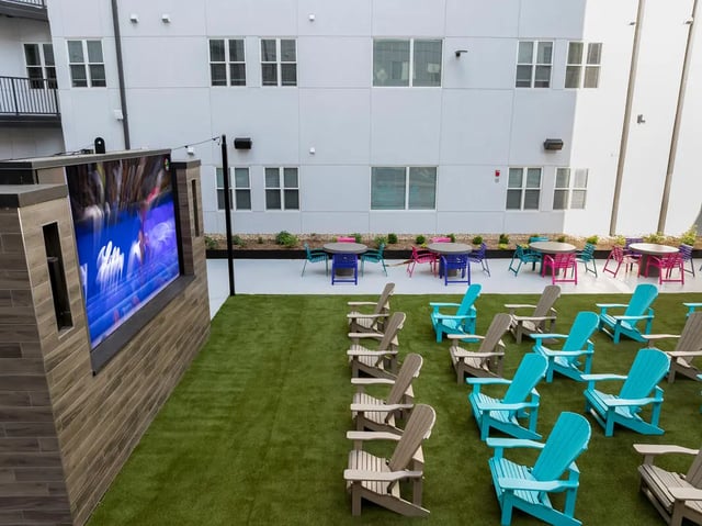 Outdoor movie screen tables chairs courtyard at Atmosphere Lincoln in Lincoln Student Accommodation