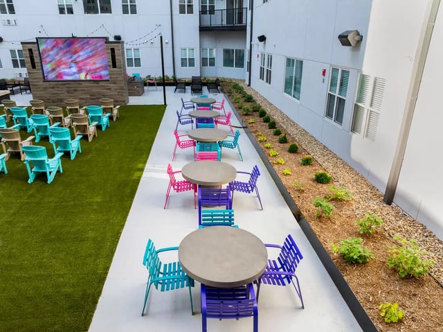 Outdoor movie screen tables chairs patio area at Atmosphere Lincoln in Lincoln Student Accommodation